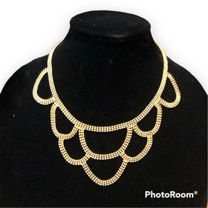 Delicate goldtone lace-like style bib necklace.